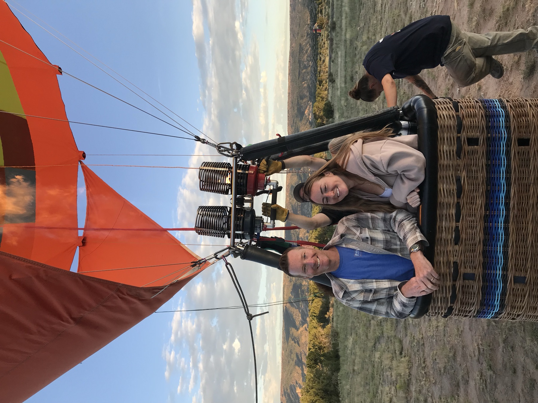 Josh and Amie smiling from a balloon basket over the New Mexico desert